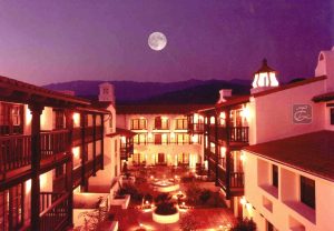 A full moon rises over the courtyard of an inn.